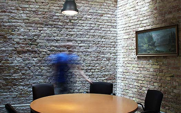 man in blue shirt behind a round table